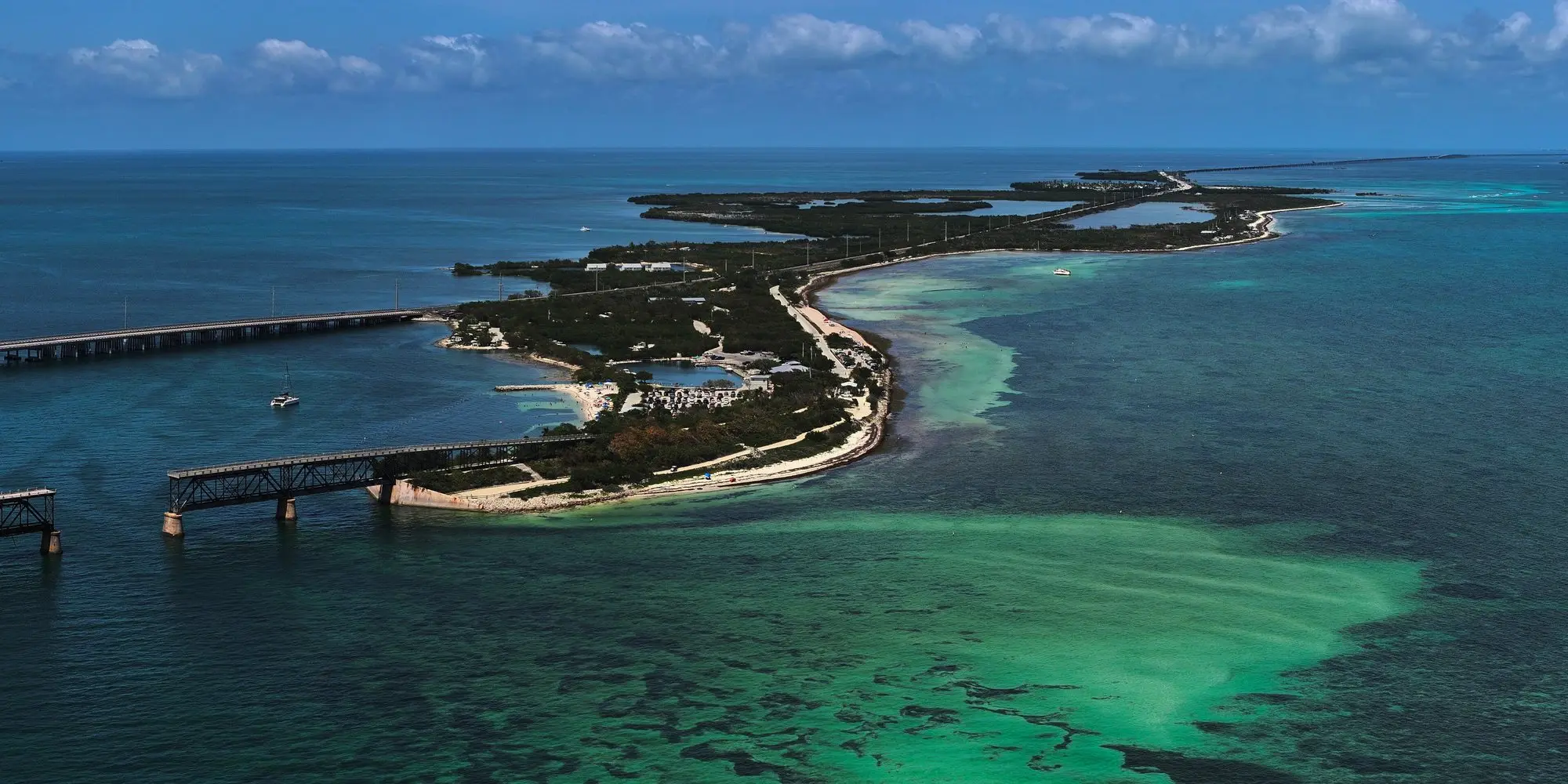 Aerial view of Bahia Honda Key with its old rail bridge, white sand and shallow green water