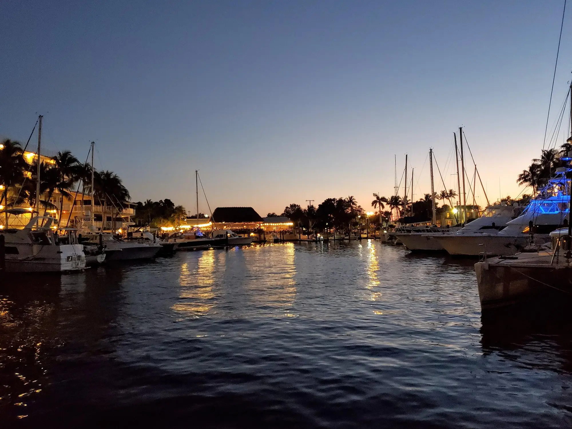 Sailboats and docks reflected in a Key Largo marina at dusk