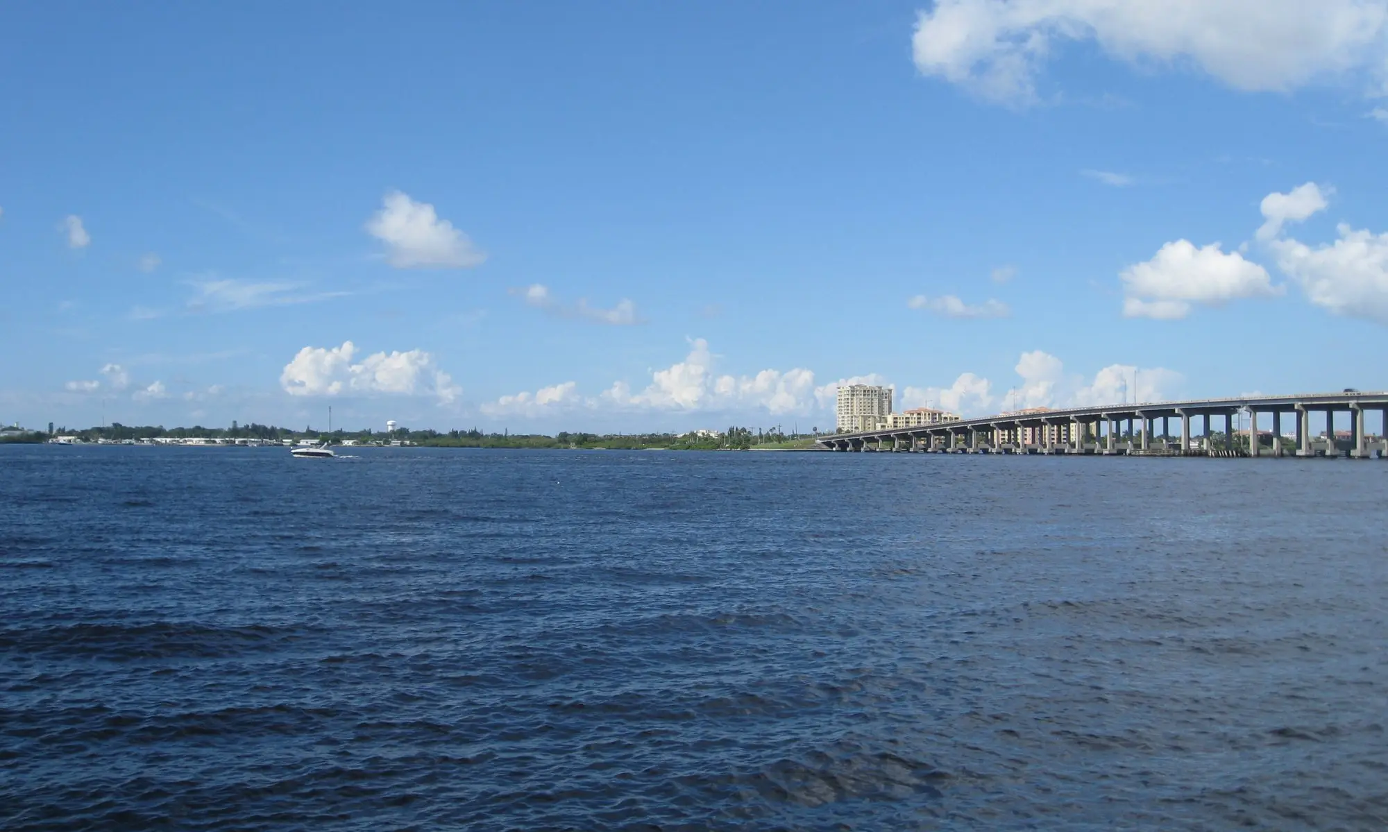The wide Manatee River from the Bradenton Riverwalk with the DeSoto Bridge in the distance