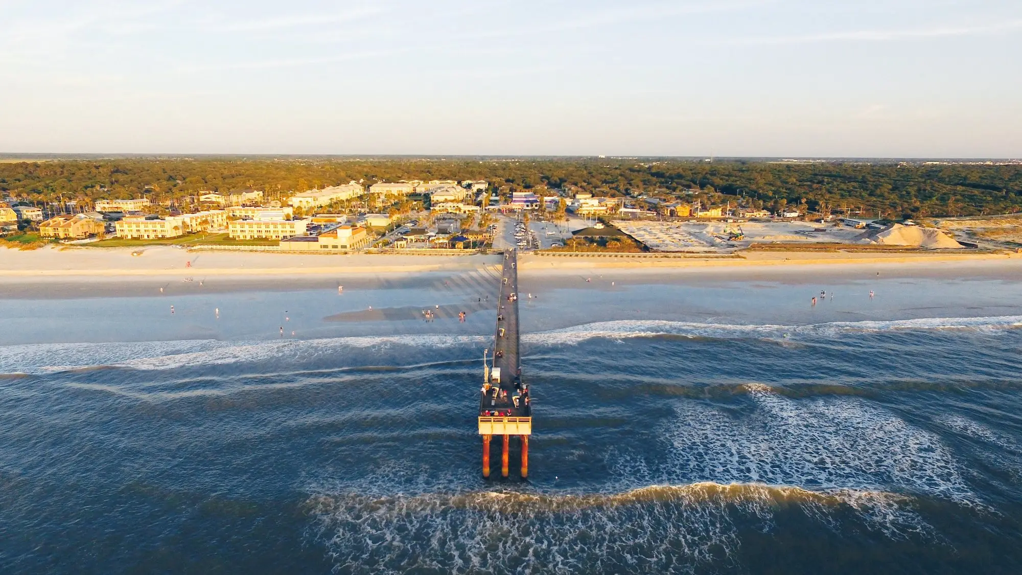 Aerial view of the St. Johns County Ocean Pier reaching into the surf at St. Augustine Beach