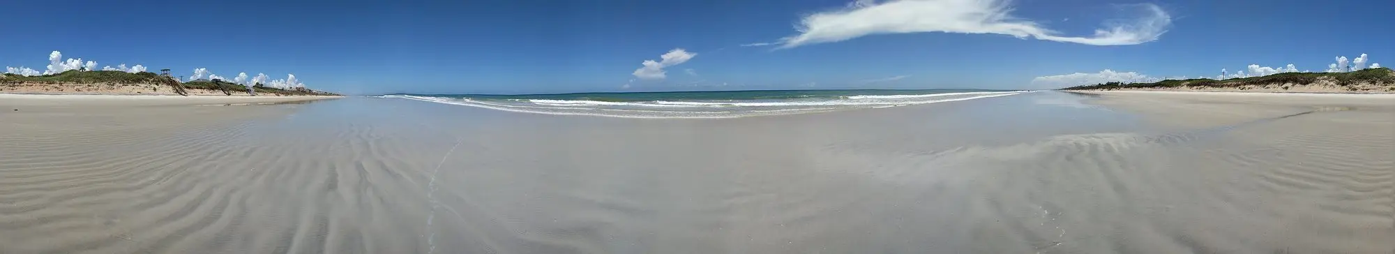 Wide, flat sand and shallow surf at South Ponte Vedra Beach under a clear sky